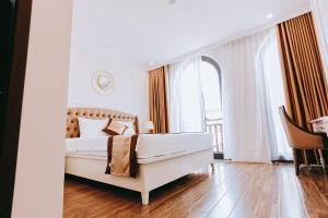 a bedroom with a bed and a large window at Golden Sea Hotel in Ha Long