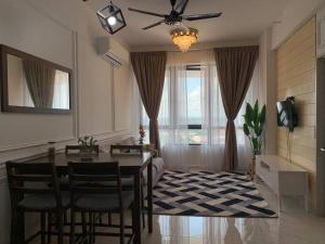 a living room with a dining room table and a ceiling fan at Lovely 2-BR service apartment with pool (melur @ troikaKB) in Kota Bharu