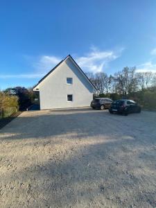 una casa con dos coches aparcados en un estacionamiento en Haus Wesloer Landstraße 6b für 4 Personen, en Lübeck