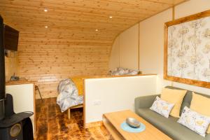 uma sala de estar com um sofá e uma cama em Fell View Park Escape Pods with hot tubs em Kirkby Lonsdale