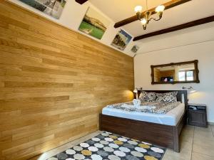 sypialnia z drewnianymi ścianami i łóżkiem z lustrem w obiekcie Vöröskő Apartman Alsóörs w Alsóörs