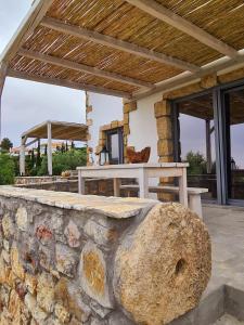 a stone wall in front of a house with a table at Koroni Stone House, newly built studios by the sea in Koroni