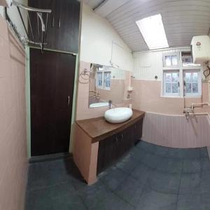 a large bathroom with a sink and a mirror at Basnet Apartment in Darjeeling +1 photo