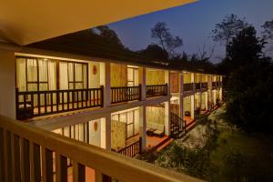 een verlicht gebouw met een balkon in de nacht bij Jagatpur Lodge in Khargauli