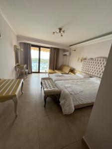 a bedroom with a large bed and a room with a window at Palatino Hotel in Parga