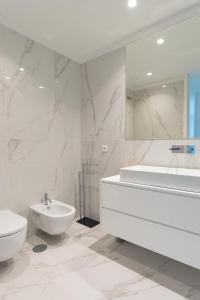 een witte badkamer met een wastafel, een bad en een toilet bij Sun&Sea Luxury Apartment by MP in Vila Nova de Gaia
