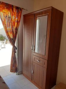 un gran armario de madera en una habitación con ventana en Chez MAX et KHADY, en Dakar