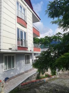 un edificio blanco con balcones rojos en Yavuz Luxury Apartments, en Macka