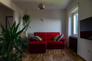 a living room with a red couch and a plant at Finestra sul mare in Recanati