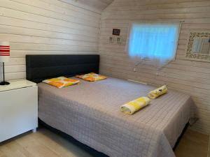 ein Schlafzimmer mit einem Bett mit zwei Kissen darauf in der Unterkunft Loistava Aurinkoranta Mökki in Ähtäri
