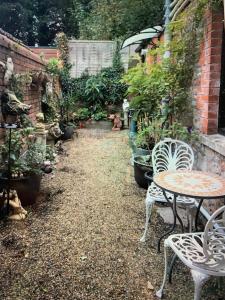 a garden with a table and chairs and potted plants at The Courtyard in Wells