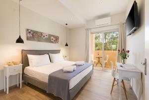 um quarto com uma cama, uma escrivaninha e uma televisão em Senses Suites em Dassia