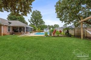 a yard with a house and a swimming pool at Coastal Retreat home in Navarre