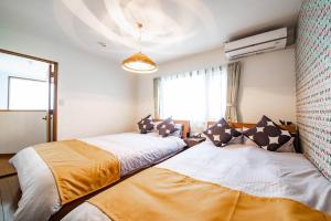 a bedroom with two beds and a window at THE BEEHIVEⅠ in Sapporo