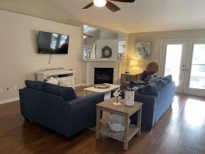 a living room with two blue couches and a tv at Coastal Retreat home in Navarre