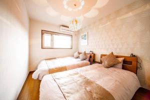 a bedroom with two beds and a chandelier at THE BEEHIVEⅠ in Sapporo