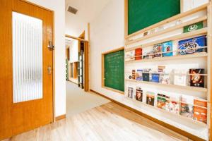 een klaslokaal met een schoolbord aan de muur en een deur bij NUPURI in Otaru