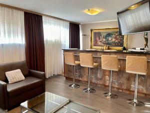 a living room with a bar with a couch and chairs at Gościniec Raciborski in Racibórz