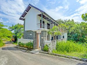 a house on the side of a road at OYO 91123 Madhava 108 in Ungasan