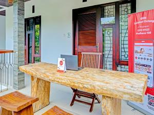 a wooden table in front of a building at OYO 91123 Madhava 108 in Ungasan