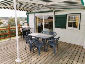 a patio with a table and chairs on a deck at Mobil Home L'Evasion in Brem-Sur-Mer