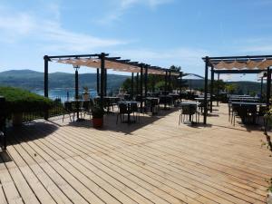 a wooden deck with tables and chairs on it at auberge du castellas in Sainte-Croix-de-Verdon