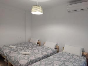 Habitación con 2 camas individuales y lámpara. en Guimar Momentos, vívelos en Córdoba, en Córdoba