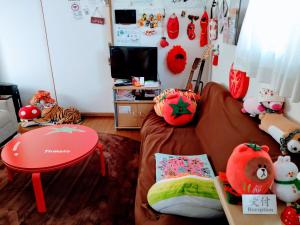 Osaka Tomato Guesthouse في أوساكا: غرفة معيشة مع أريكة وطاولة
