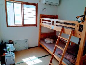 Pokój z 2 łóżkami piętrowymi i oknem w obiekcie Osaka Tomato Guesthouse w Osace