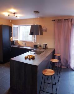 a kitchen with a large island with stools in it at Grande maison près de Bordeaux Parking Pétanque WiFi in Beychac-et-Caillau