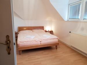 Un dormitorio con una cama en una habitación con ventana. en Blue House, en Győrzámoly 15 fotos más