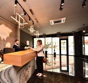 a man and a woman standing at a reception desk at King Solomon Batumi Hotel in Batumi