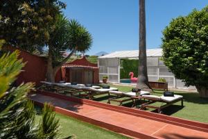 un grupo de mesas y bancos en un patio en KARAT Villa Fernanda, en Tacoronte