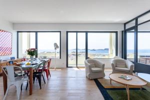a dining room and living room with a table and chairs at HORIZON MER - Splendide vue Mer et îles in Marseille