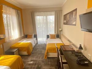 Pokój hotelowy z 2 łóżkami i biurkiem w obiekcie Hotel Vitalia w Boszkowie