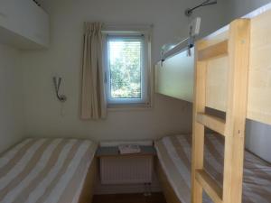 a bedroom with two bunk beds and a window at De Boomhut in Buren
