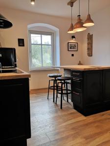 a kitchen with a counter and stools in a room at Klimatyczne Apartamenty Złoty Stok in Złoty Stok