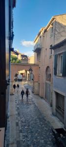 a group of people walking down a street with umbrellas at Beau studio en centre ville in Narbonne