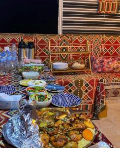 a table with plates of food on top at Adam Bedouin camp in Wadi Rum