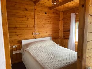 a bedroom with a bed in a wooden cabin at Agradable Mini Casa de madera con jardín amplio in Las Lagunas