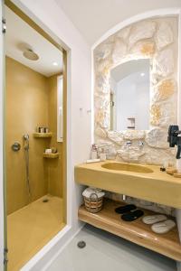 a bathroom with a sink and a mirror at Flèria Seaview Suites in Naxos Chora