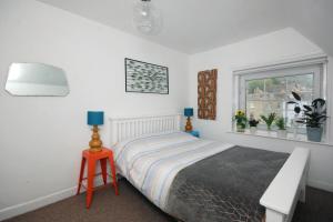 a bedroom with a bed and a table and a window at Enjoy Ventnor 2, Pier Street, Wightlink offer in Ventnor