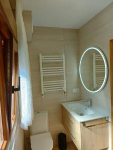 ein Badezimmer mit einem WC, einem Waschbecken und einem Spiegel in der Unterkunft Casa Flori in Celorio