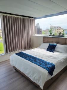 een bed in een slaapkamer met een groot raam bij Eli House in Toucheng