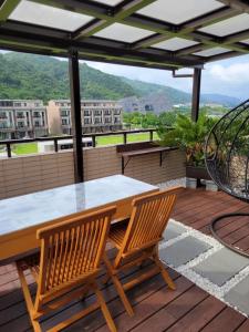 une table et deux chaises sur une terrasse avec vue dans l'établissement Eli House, à Toucheng