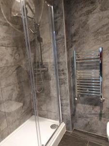 a shower with a glass door in a bathroom at Apartment & Rooms in London in Croydon