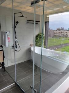 a bathroom with a tub and a glass shower at Eli House in Toucheng