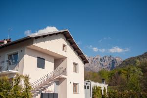 a white building with mountains in the background at Maison Lirà in Pren