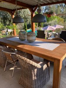 una mesa de madera con sillas de mimbre y dos luces colgantes en Porturama, en Mouronho