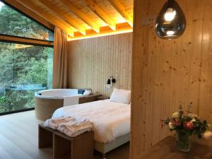 1 dormitorio con bañera, cama y mesa en Complejo Turístico Rural A TORRE DE LAXE, en Laxe